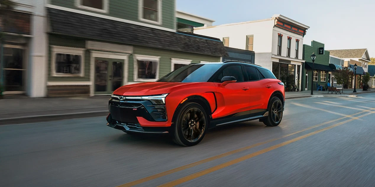 Red Chevrolet Blazer EV driving along an urban street