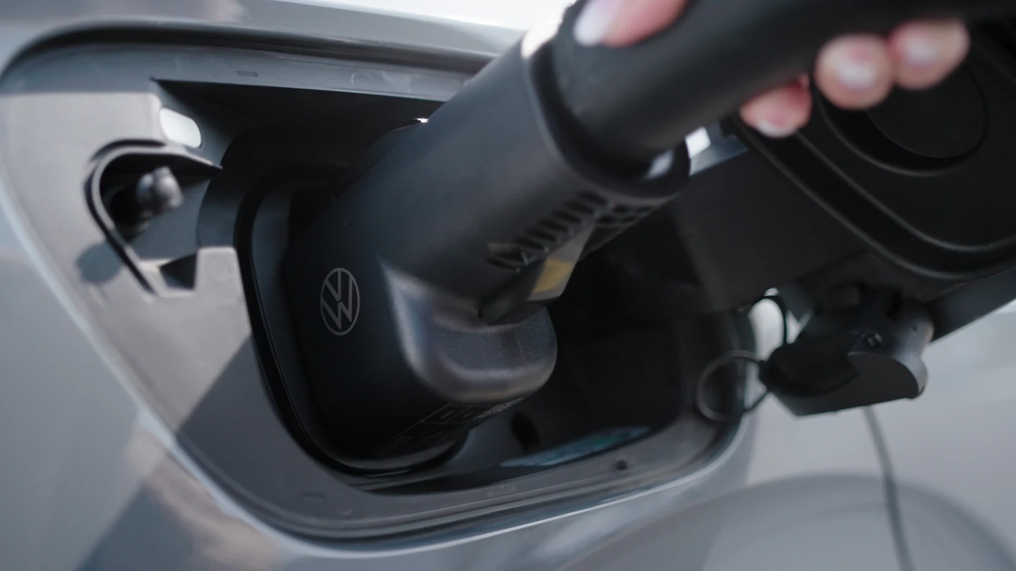 Close-up of a Volkswagen NACS DC adapter connected at an ID.4 charging inlet.
